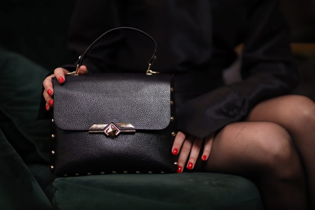 Model drži Cube Mini kožnu torbu Manir u elegantnoj crnoj varijanti